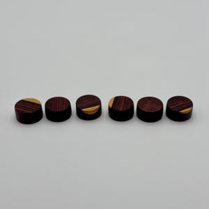 May include: Six round wooden guitar knobs with a dark brown and gold wood grain pattern.