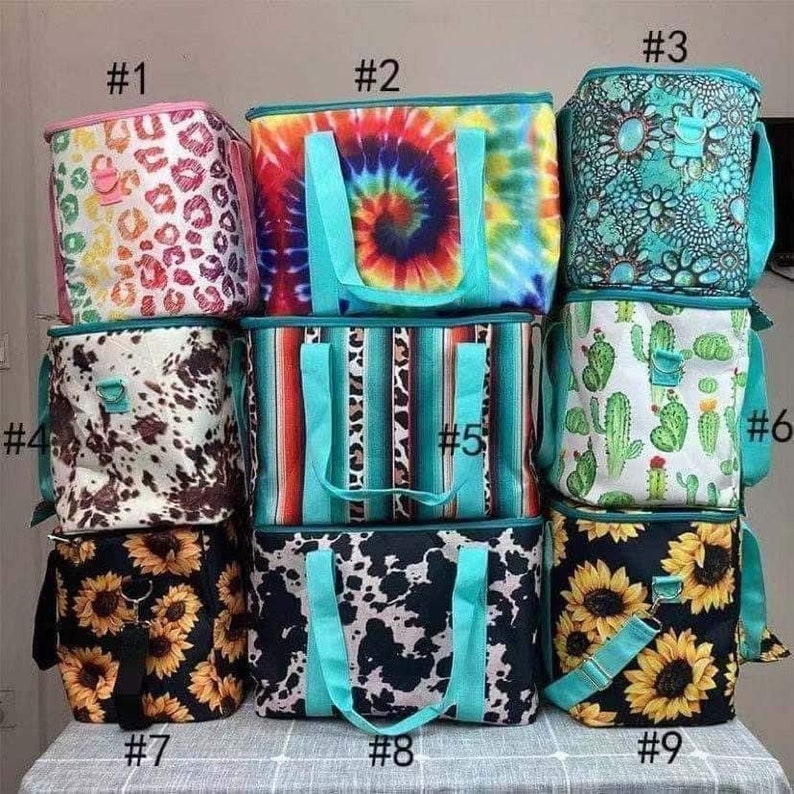 May include: A collection of insulated tote bags with various patterns. Designs include tie-dye, animal print, cactus, sunflowers, and cowhide. Each bag has a matching teal handle and trim. The bags are designed to keep items cold.