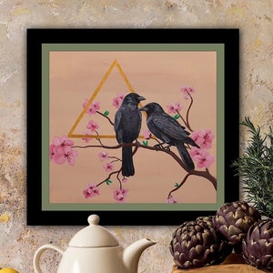 Black frame with a green matte. Painting of two black crows on a cherry blossom branch and a unique golden metallic triangle. Crow Couple Painting.