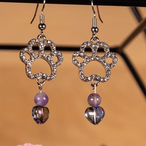 Silver Paw Print Dangle Earrings with purple accent beads and nickel free silver hooks.