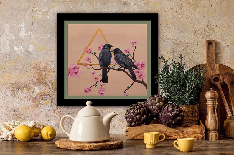 Black frame with a green matte. Painting of two black crows on a cherry blossom branch and a unique golden metallic triangle. Crow Couple Painting.