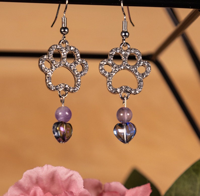 Silver Paw Print Dangle Earrings with purple accent beads and nickel free silver hooks.