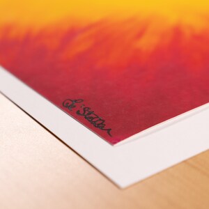 May include: An abstract art print featuring a gradient of colors, transitioning from yellow to red. The artwork is signed "Le Stella" in black ink in the lower left corner. The print is mounted on a white border.
