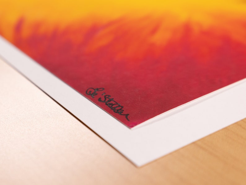 May include: An abstract art print featuring a gradient of colors, transitioning from yellow to red. The artwork is signed "Le Stella" in black ink in the lower left corner. The print is mounted on a white border.