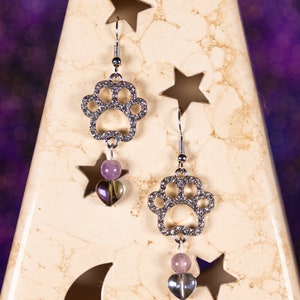 Shiny paw print earrings accented with rhinestones and purple beads.