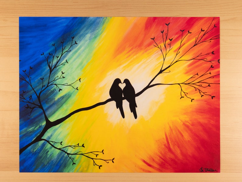 May include: Colorful abstract painting of two birds silhouetted on a branch, forming a heart shape with their beaks. The background transitions from blue to yellow to red. The artwork is signed in the lower right corner.