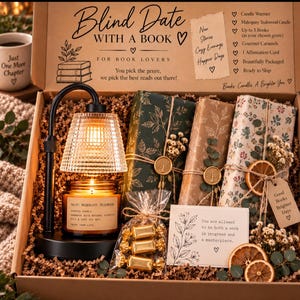 May include: A Blind Date With A Book gift box containing a black candle warmer with a glass shade, a Mahogany Teakwood candle, three wrapped books with dried floral accents, gold-wrapped caramels, and an affirmation card with printed text.
