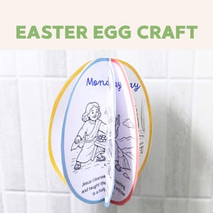 May include: An Easter egg craft with the text "Easter Egg Craft" in green. The egg-shaped craft is multi-layered, with illustrations and text inside. The edges are outlined in blue, yellow, and pink.