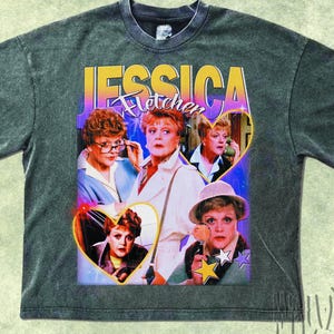 Puede incluir: Camiseta gris oscuro con un diseño retro que presenta el texto "JESSICA Fletcher" en amarillo y morado. El gráfico incluye imágenes del personaje Jessica Fletcher de la serie de televisión "Se ha escrito un crimen".