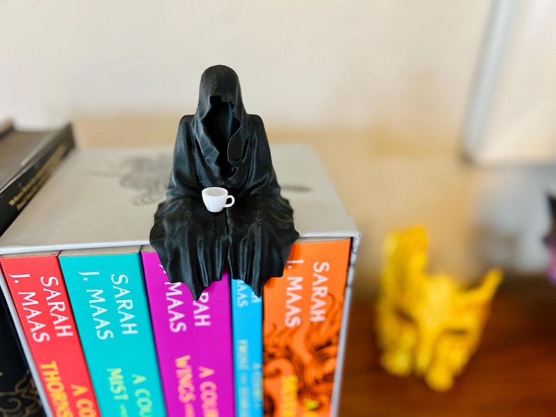 Suriel bokhylledekoration Suriel tebokhylledekoration Liemannen sittande bokhylla med tekoppfigur bild 1
