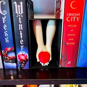 Insert de bibliothèque gothique pour coin livres Pomme de tentation, mains tenant un présentoir pomme pour les amateurs de lecture