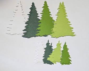 May include: Paper cutouts of evergreen trees in shades of green and white are arranged on a white background. The trees vary in size and shade, creating a layered effect. The design evokes a forest scene.