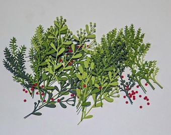 May include: A collection of paper cutouts of green leaves and sprigs with small red berries. The leaves vary in shape and shade, ranging from light to dark green. The red berries are scattered among the leaves, creating a festive look.