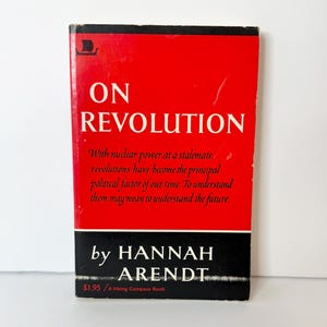 May include: A paperback book titled On Revolution by Hannah Arendt. The cover is bright red with a black horizontal band at the bottom. The text reads: On Revolution, With nuclear power at a stalemate, revolutions have become the principal political factor of our time. To understand them may mean to understand the future, by Hannah Arendt, $1.95 / A Viking Compass Book.