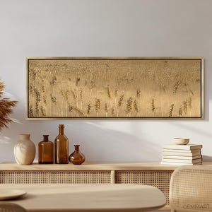Puede incluir: Una impresi&oacute;n en lienzo larga y horizontal que presenta un campo de espigas de trigo doradas. La impresi&oacute;n est&aacute; enmarcada en un marco de madera delgado y se muestra en una pared sobre un estante de madera con objetos decorativos.