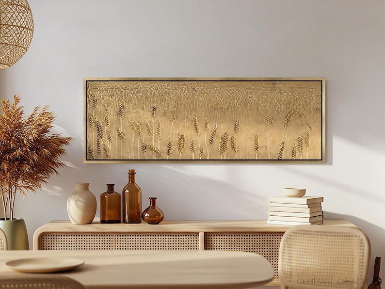 Puede incluir: Una impresi&oacute;n en lienzo larga y horizontal que presenta un campo de espigas de trigo doradas. La impresi&oacute;n est&aacute; enmarcada en un marco de madera delgado y se muestra en una pared sobre un estante de madera con objetos decorativos.