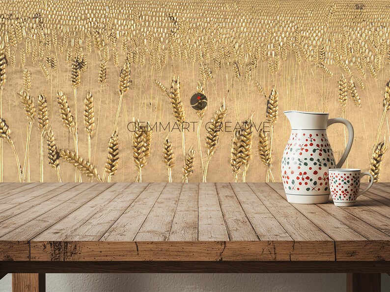 Puede incluir: Una mesa de madera r&uacute;stica se encuentra frente a una pared con un dise&ntilde;o de campo de trigo dorado. Una jarra blanca con estampado floral rojo y verde y una taza blanca con un estampado similar est&aacute;n sobre la mesa.