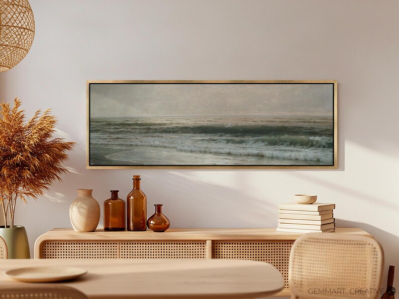 May include: A framed seascape painting with a muted color palette depicting a stormy ocean with waves crashing against the shore. The painting is displayed on a light wood shelf with decorative vases and bottles.