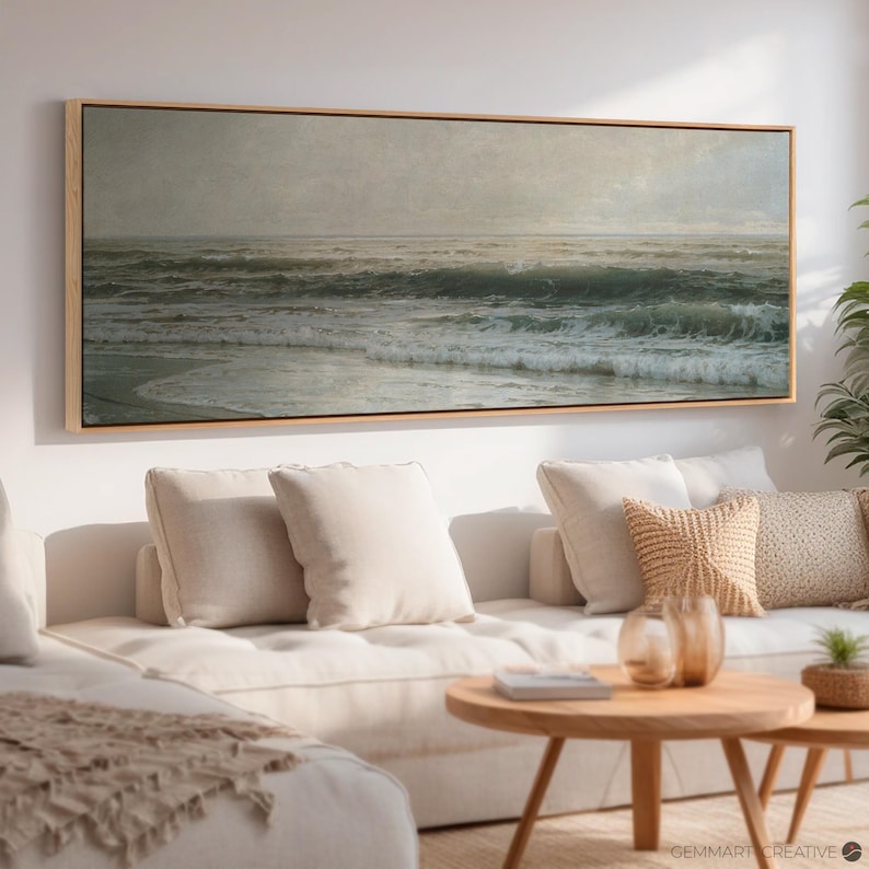 May include: A framed painting of a seascape with waves crashing on the shore. The painting is in a light wood frame and is hanging on a white wall.