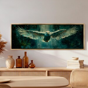May include: A framed canvas print of a white eagle in flight against a dark green and blue background with white speckles. The eagle is flying towards the viewer with its wings spread wide. The background is blurred and has a watercolor effect.