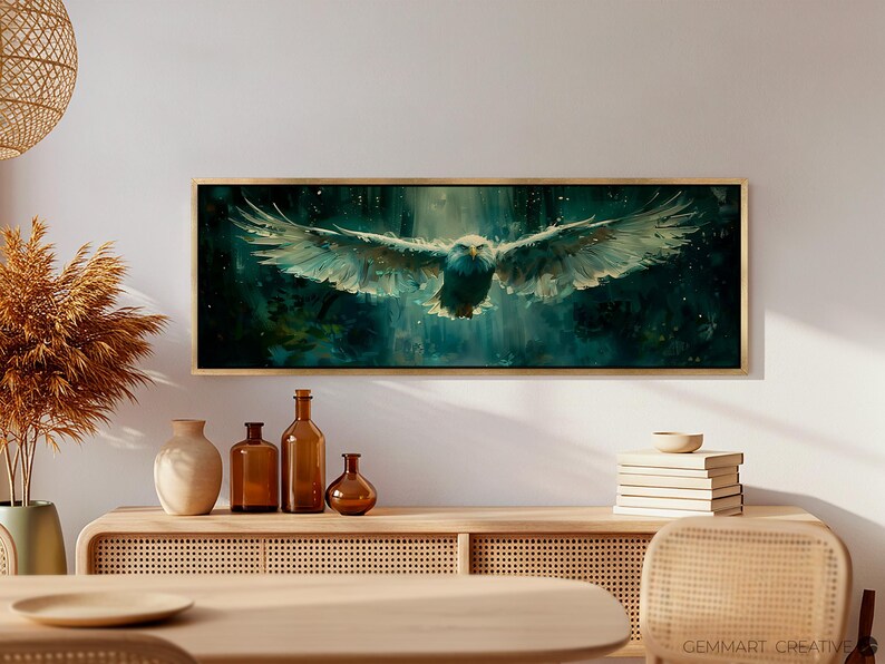 May include: A framed canvas print of a white eagle in flight against a dark green and blue background with white speckles. The eagle is flying towards the viewer with its wings spread wide. The background is blurred and has a watercolor effect.
