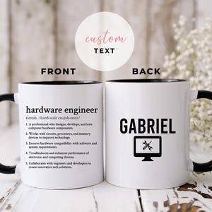 Puede incluir: Taza de cerámica blanca con borde y asa negros. La parte delantera de la taza tiene la definición de "ingeniero de hardware" impresa en texto negro. La parte posterior de la taza tiene el nombre "GABRIEL" impreso en texto negro con un icono de monitor de ordenador y dos destornilladores cruzados dentro del monitor.