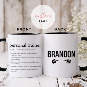 Może przedstawiać: Biały ceramiczny kubek do kawy z czarnym rantem i uchwytem. Na przodzie kubka znajduje się definicja "personal trainer" wydrukowana czarnym tekstem. Na odwrocie kubka znajduje się imię "BRANDON" wydrukowane czarnym tekstem z grafiką hantle.