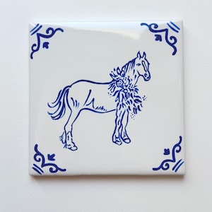 May include: A square white ceramic tile featuring a blue outline of a horse adorned with floral details. The tile has decorative blue corner accents. This decorative tile is suitable for home decor.