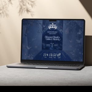 May include: A laptop displays a Quincea&ntilde;era invitation. The screen shows a dark blue background with a tiara graphic and the text "Summer Smith's Quincea&ntilde;era." A countdown timer is visible at the bottom. The laptop is on a gray surface.