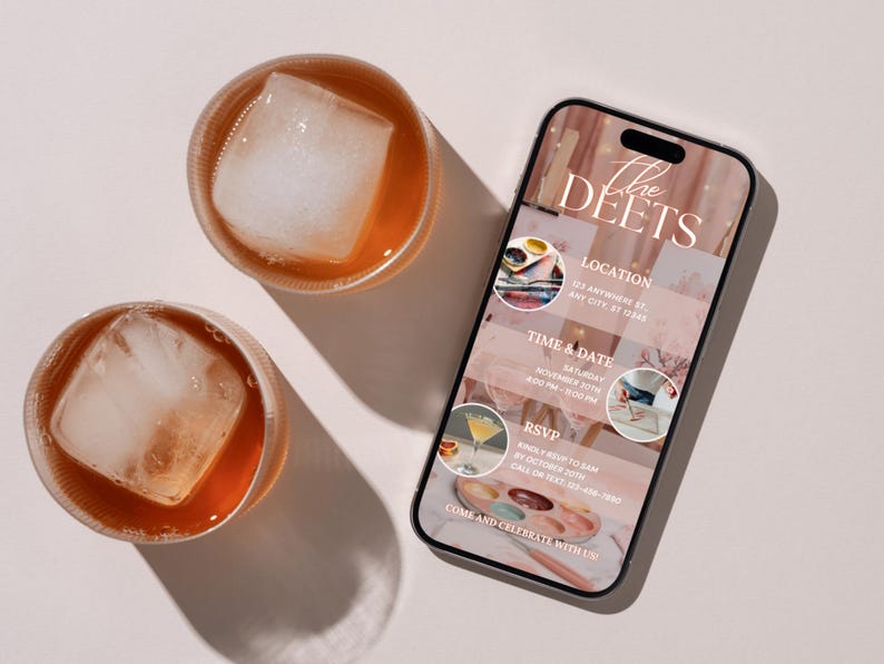 May include: Two glasses of amber-colored liquid with large ice cubes sit next to a smartphone. The phone displays an invitation with the text "The Deets", location, time, date, and RSVP information. The invitation has a pink and white color scheme.