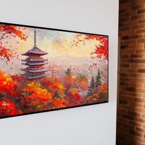 以下が含まれることがあります： 鮮やかな赤とオレンジの紅葉に囲まれた日本の塔の額入り絵画。このアートワークは、都市とカラフルな空を背景に、多層構造を描いています。絵画は白い壁に取り付けられています。