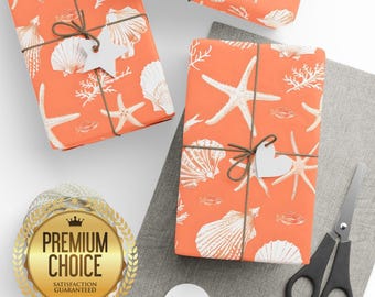 May include: Three wrapped gifts with orange paper featuring a white seashell and starfish pattern. Each gift is tied with brown twine and a white tag. A pair of black scissors and a gold "Premium Choice" seal are also visible.