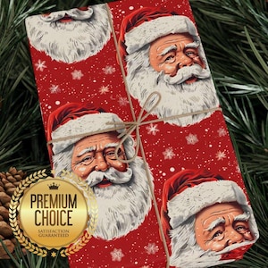 Könnte beinhalten: Ein Geschenk, verpackt in rotes Geschenkpapier mit Illustrationen von Weihnachtsmann-Gesichtern und Schneeflocken. Das Geschenk ist mit Bindfaden verschnürt und hat ein goldenes Siegel mit der Aufschrift "Premium Choice" und "Satisfaction Guaranteed".