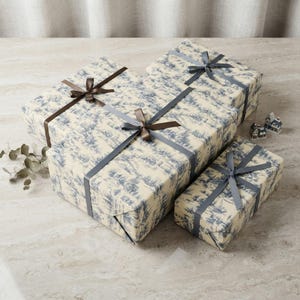 Blue Toile Winter Village Christmas Gift Wrap Rolls shown in an AI-generated listing photo
