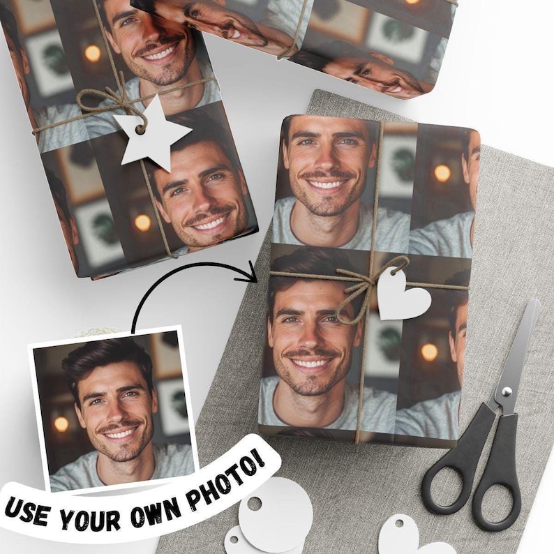 May include: Custom wrapping paper featuring a repeating photographic print of a smiling person wearing a grey shirt. The paper is tied with brown twine and decorated with a white star-shaped tag. A pair of black scissors is placed nearby.