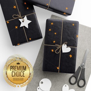 May include: Black wrapped gifts with orange star accents and twine. Each gift has a white tag in the shape of a star or heart. A gold seal with the words "Premium Choice" is also visible.
