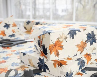Rollo de papel de regalo con hojas de arce azules y naranjas para regalar en otoño, Acción de Gracias y cumpleaños. Papel de regalo otoñal para un acogedor regalo de Halloween.