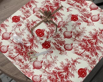 Papel de regalo navideño con estampado Toile rojo, adornos vintage y árboles nevados.