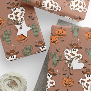 Könnte beinhalten: Braunes Geschenkpapier mit einem sich wiederholenden Muster aus einem Geist mit Cowboyhut, Kürbissen, Kakteen und Fledermäusen. Die verpackten Geschenke sind mit Bindfaden gebunden und haben stern- und herzförmige Anhänger.