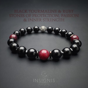 Op de afbeelding: Een kralenarmband met gepolijste zwarte toermalijn en rode robijn bollen, geaccentueerd met kleine metalen tussenstukjes en een getextureerde zilveren kraal. De tekst luidt: BLACK TOURMALINE & RUBY STONES OF PROTECTION, PASSION & INNER STRENGTH. INSIGNIS.