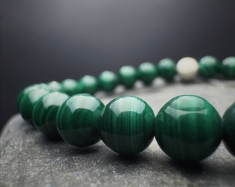May include: A green malachite beaded bracelet with a silver accent bead.