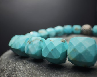May include: A turquoise gemstone bracelet with faceted beads and a silver accent. The bracelet is made of natural turquoise stones and is a beautiful and unique piece of jewelry.