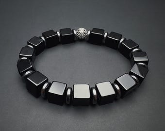 May include: A black onyx bracelet with silver square beads and a silver bead in the center.