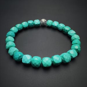 May include: A turquoise gemstone bracelet with faceted beads and a silver bead accent.