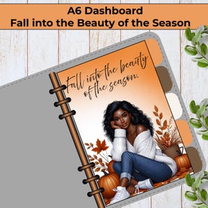 May include: An A6 dashboard planner insert featuring an illustration of a person with long dark hair wearing a white sweater and blue jeans. The background shows orange autumn leaves and pumpkins with the text, Fall into the beauty of the season.