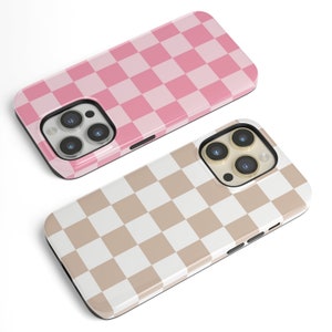 May include: Two phone cases with a checkered pattern. One case is pink and white, the other is beige and white.