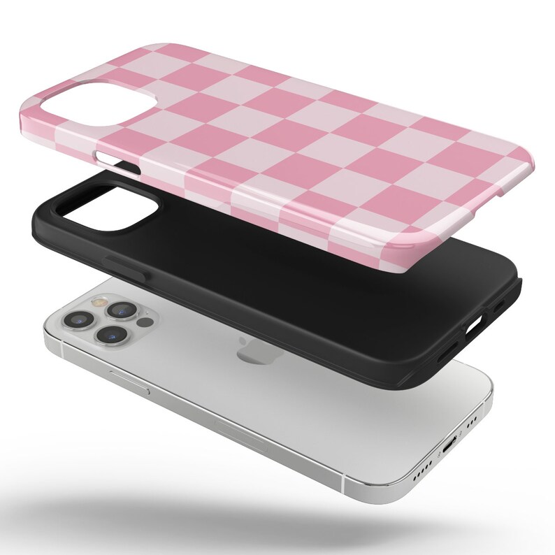 May include: A pink and white checkered phone case for an iPhone 13 Pro Max. The case is shown in three parts: the phone case, the black bumper, and the phone itself.