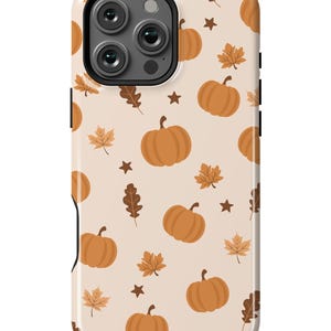 Puede incluir: Una funda de tel&eacute;fono beige con un patr&oacute;n de calabazas naranjas y hojas marrones. La funda tiene un recorte para el objetivo de la c&aacute;mara.