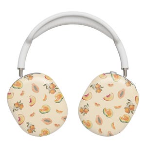 May include: White wireless headphones with a cream-colored design featuring a pattern of peaches, cantaloupe, and orange slices.
