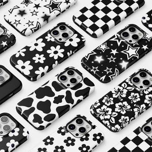Może przedstawiać: Kolekcja 12 r&oacute;żnych etui na telefon z czarno-białymi wzorami. Wzory obejmują gwiazdy, kwiaty, wz&oacute;r krowy, szachownicę, serca i kwiaty hibiskusa.